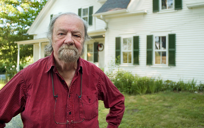 Donald Hall standing in front of a house